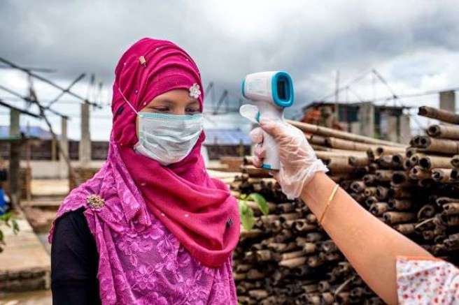 Hazera gets her temperature taken outside ActionAid’s women-friendly space in a Rohingya refugee camp in Cox’s Bazar, Bangladesh.